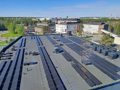 Aurinkopaneelit sairaalarakennuksen katolla, taustalla näkyy muita rakennuksia.