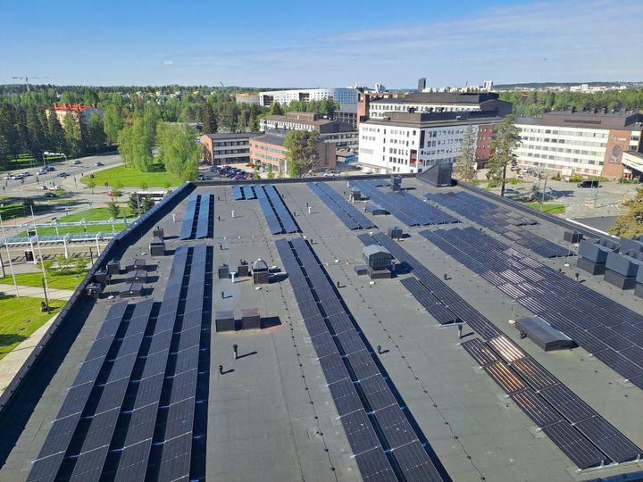 Aurinkopaneelit sairaalan katolla, taustalla näkyy Tampereen rakennuksia.