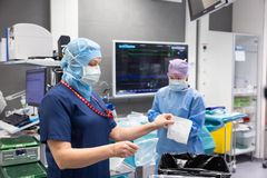 Sairaalan henkilökunta lajittelee jätteitä leikkaussalissa.