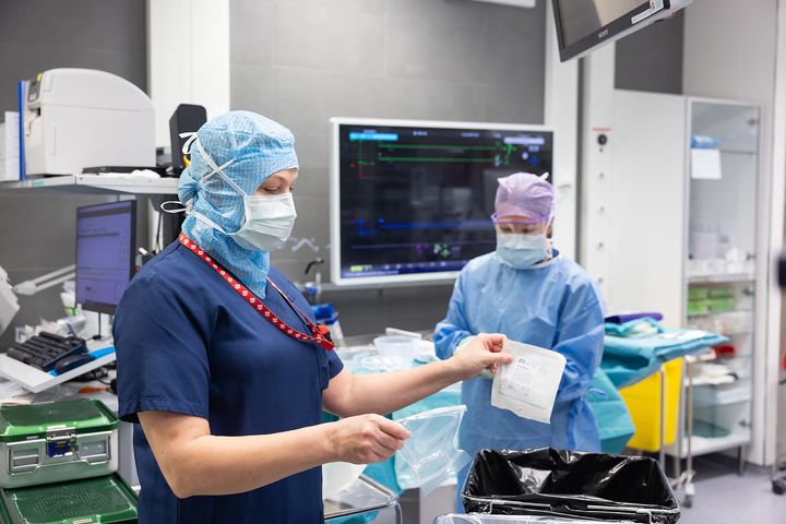 Sairaalan henkilökunta lajittelee jätteitä leikkaussalissa.