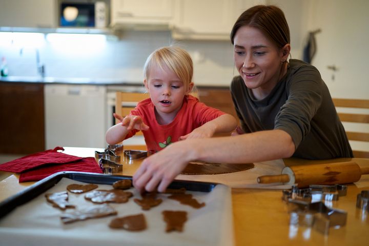 En mamma bakar pepparkakor med sin dotter.