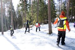 Joukko Vapepan vapaaehtoisia kävelemässä lumisessa metsässä.