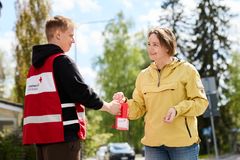 En person i Röda Korset-väst tar emot en donation från en annan person.