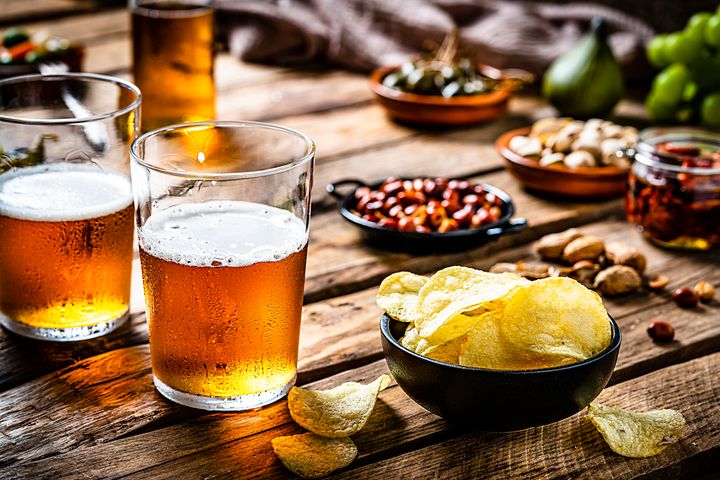 Olut- ja perunalastut maalaismaisella puupöydällä