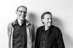 Portrait of two men smiling. A black and white photo.