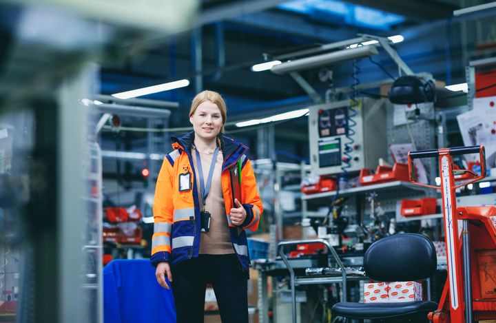 Kierrätyksen asiantuntija seisoo etualalla kierrätyslaitoksessa