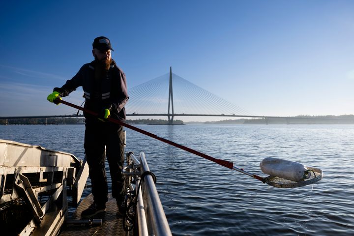 Staran meri- ja saaristopalveluiden työntekijä Lippo-aluksella nostamassa roskaa merestä.