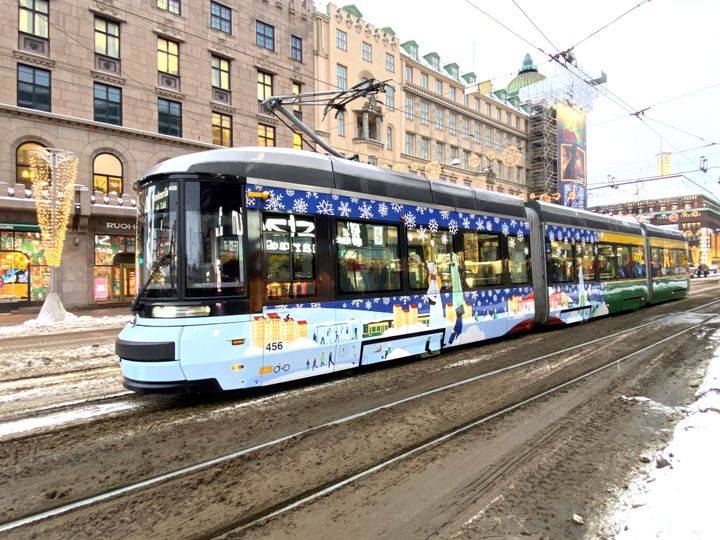 Talvista maisemaa kuvaavalla teippauksella koristeltu raitiovaunu Helsingin keskustassa.