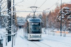 Kuvassa pikaratikka lumisessa maisemassa.