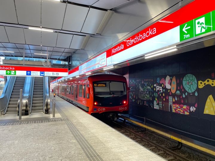 Metro lähdössä asemalta, kuvassa metrolaituri ja liukuportaat.