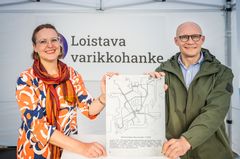Kuvassa tilaajan projektijohtaja Lotta Koski-Lammi ja allianssin projektipäällikkö Antti Leskinen pitelevät muistolaattaa,  josta löytyvät tämän päivän raitiolinjat ja teksti tontin historiasta.