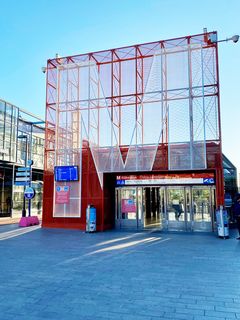 Punainen metroaseman sisäänkäynti, jossa suuri M-kirjain.