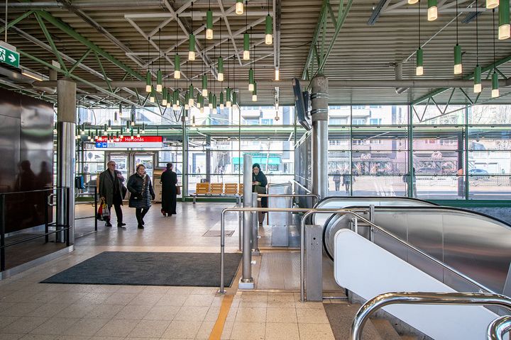 Ihmisiä Herttoniemen metroaseman lippuhallissa.