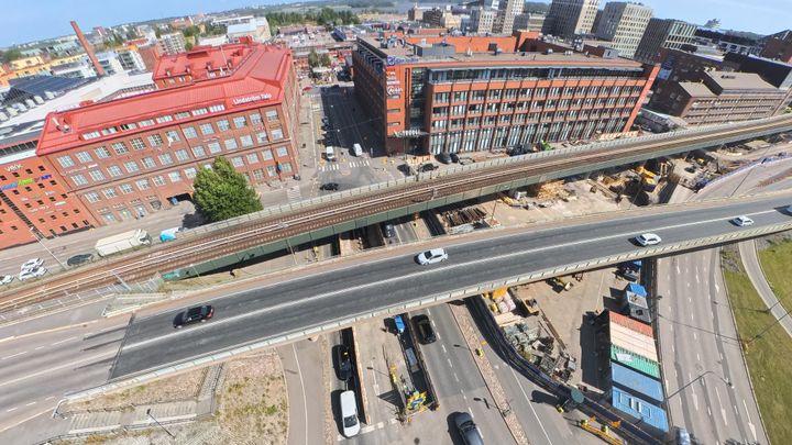 Ilmakuva Junatiestä ja Junatien metrosillasta sekä Sörnäisten rantatiestä, jolla on autoja liikenteessä.