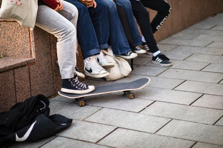 Nuorten jalkoja ja skeittilauta.