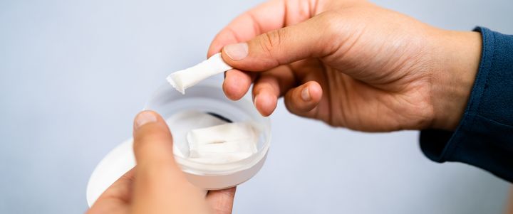 En person håller nikotinprodukter i handen