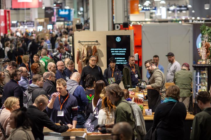 Paljon ihmisiä messuosastoilla.