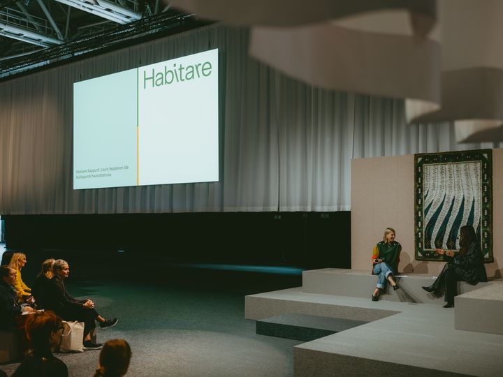 Habitaren 2025 päälavalla on keskiviikosta alkaen kuultu asumiseen, muotoiluun ja sisustamiseen liittyvää ohjelmaa Ida Kukkapuron juontamana. Perjantai-iltana designkatsomo muuntuu kisakatsomoksi, jossa jännitetään Susijengin ottelua Saksan kanssa kello 17 alkaen. Kuva: Habitare / Henry Vogt