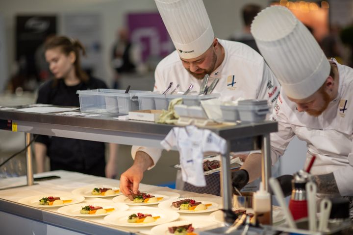 Kokki asettelee huolellisesti annoksia lautasille Gastro-messuilla.