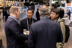 Ryhmän ihmisiä keskustelemassa ja pitelemässä kahvikuppeja tapahtumassa.