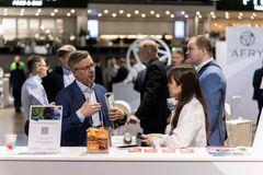 Messuosallistujia keskustelemassa ständin äärellä.