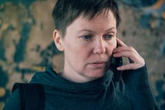 Vakava nainen puhuu puhelimessa.