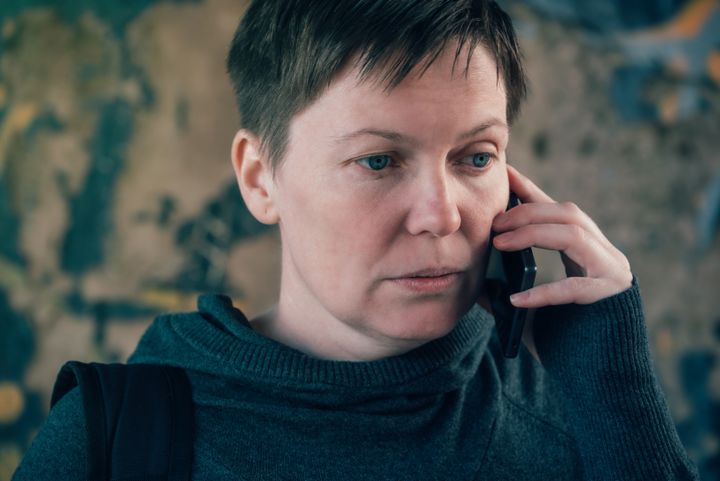 Vakava nainen puhuu puhelimessa.