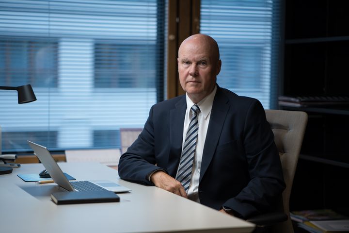 Mies istuu toimistossa tietokoneen ääressä.