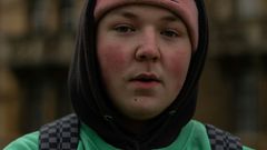 nuori katsoo kameraan