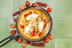 Pannukakkua, hillottua raparperia ja mansikkaa