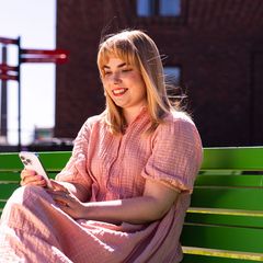 Nuori nainen katsoo puhelintaan
