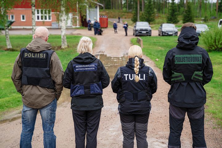 Virkapukuiset%20henkil%F6t%20Tullista%2C%20Poliisista%2C%20Rikosseuraamuslaitoksesta%20ja%20Puolustusvoimista%20seisovat%20selin%20kameraan.