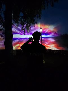 Pimeällä taivaalla värikkäänä loistava valoteos.