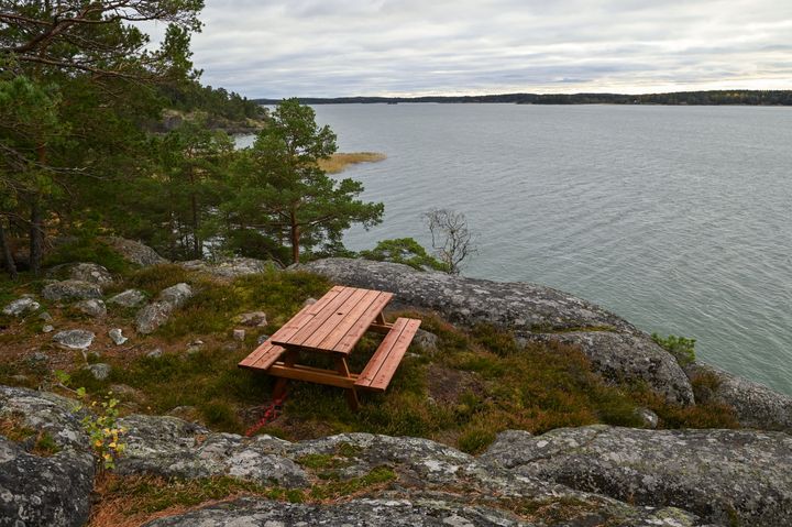 Pöytäryhmä kallioilla, taustalla meri.