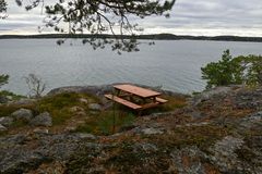 Pöytäryhmällä kalliolla, taustalla meri.