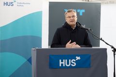 toimitusjohtaja puhuu mikrofoniin puhujapöydän takana