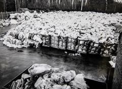 Mustavalkokuva, jossa on suuri määrä lannoitesäkkejä pihalla vuonna 1978.