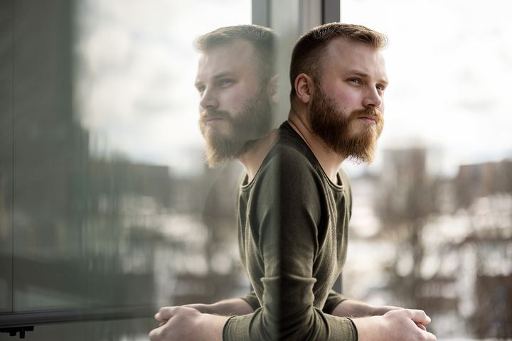 Mies katsoo parvekkeelta