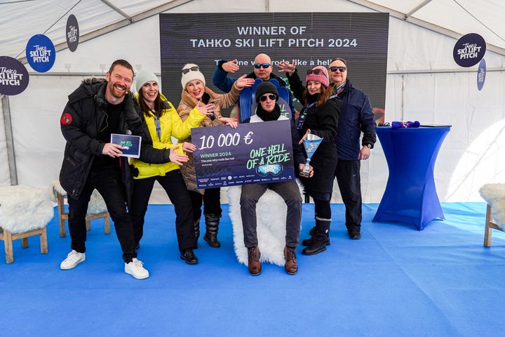 Tahko Ski Lift Pitch 2024. Juontaja Tomi Kaukinen (vas.) ja tuomariston jäsenet Vilma Torstila, Elina Koivumäki, Kim Väisänen, Noora Tuikka ja Jari Osmala. Tuolissa istumassa pitchauskilpailun voittanut PrecisionPhagen Matti Jalasvuori.