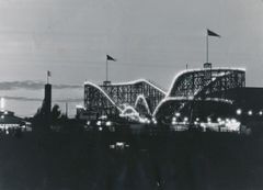 Linnanmäen Vuoristorata iltavalaistuksessa vuonna 1951, taustalla hämärtyvä taivas.