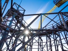 Kuvassa on Linnamäen Vuoristoradan puurakenteita sinisen taivaan alla.