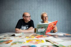 Mauri Kunnas ja Harri Römpötti lukevat Nyrok City -sarjakuvaa pöydän ääressä.