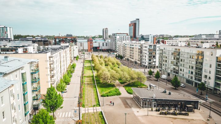 A%20photo%20taken%20from%20above%2C%20showing%20apartment%20buildings%20on%20both%20sides%20and%20tracks%2C%20trees%2C%20a%20pedestrian%20and%20bicycle%20path%20and%20a%20low-rise%20building%20in%20the%20centre.