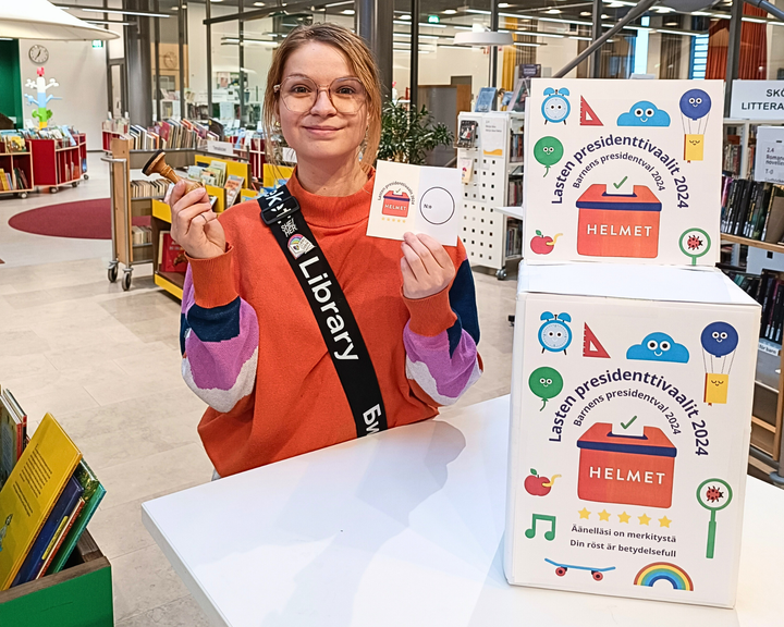 Biblioteksrådgivare Jenna Nokkala vid valurnan redo att agera som valfunktionär i barnens egna presidentval.