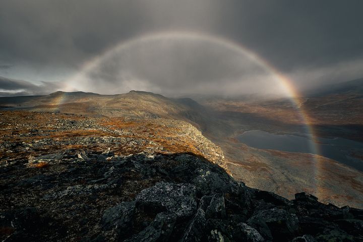 En dramatisk bild på en regnbåge i ett ståtligt fjällandskap.