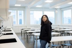 Naz Gultekin seisoo luokassa ja nojaa pöytään.