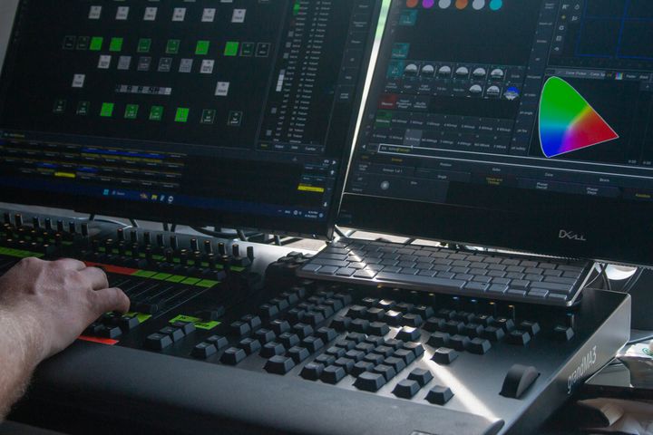 En ljudtekniker övervakar ljudåtergivningen av musiken vid mixerbordet under ett evenemang.