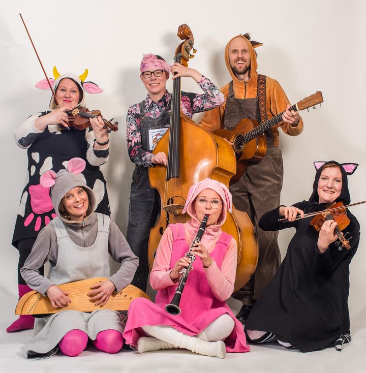 Kuusi muusikkoa eläinpuvuissa soittaen instrumenttejaan.