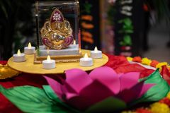 Kukka ja kynttilöitä Ganesha-asteleman ympärillä.