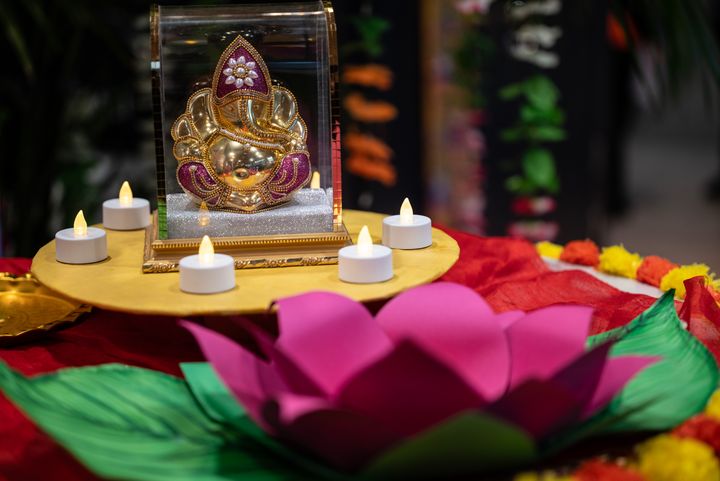 Kukka ja kynttilöitä Ganesha-asteleman ympärillä.